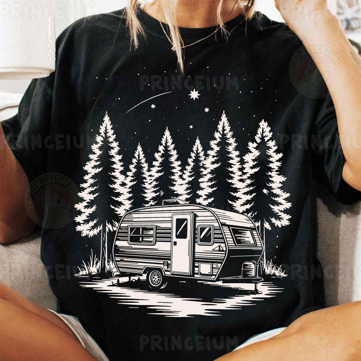 a woman sitting on a couch wearing a t - shirt with an image of a